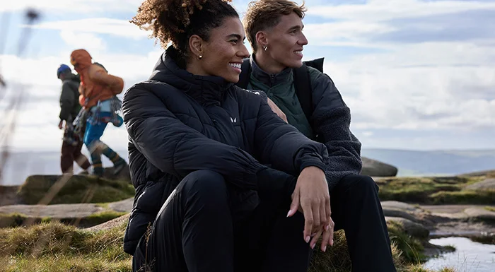 man and woman resting on hike