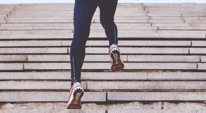 Athlete running up outdoor steps during a high-intensity interval session