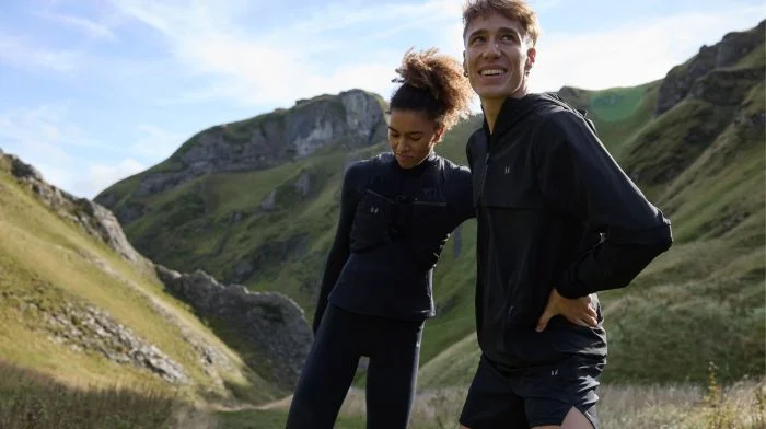 A young man and woman warming up outdoors.